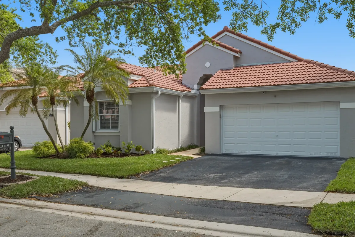 Single-story home with a tiled roof, double garage and palms