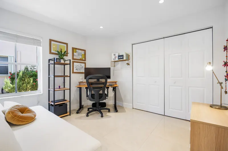 Bright room with a desk, pale sofa and sliding glass doors
