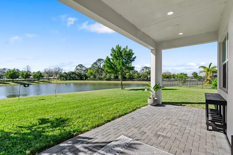 Covered paved patio looking across a green lawn to a lake